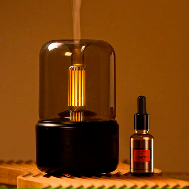 Humidificador silencioso con luz ambiental  emitiendo vapor junto a un frasco de aceite esencial